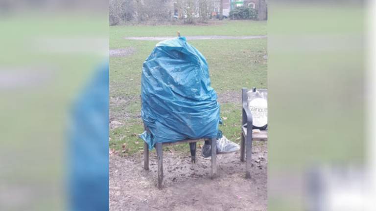 De man zit in een blauwe vuilniszak. (Foto: Politieteam Tilburg-Centrum)