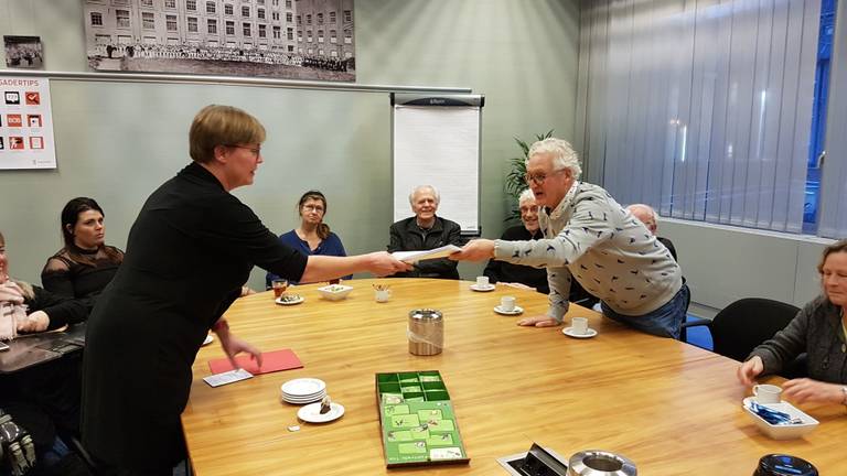 Bewoners overhandigen handtekeningen over het parkeerbeleid.