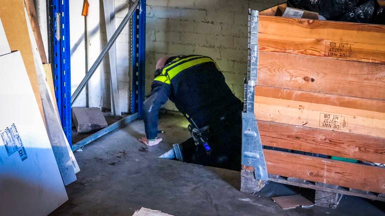 Een agent onderzoekt de ondergrondse hennepkwekerij (Foto: Sem van Rijssel/SQ Vision)