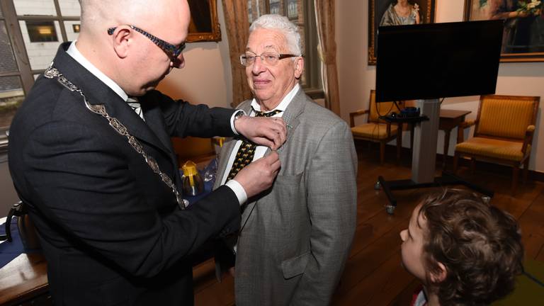 Johan Henskens krijgt de onderscheiding opgespeld (foto: Henk van Esch).