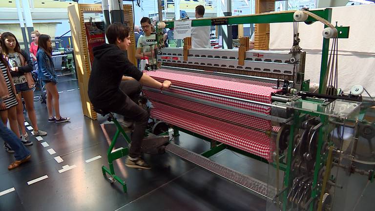 Kinderen kijken en helpen mee in het Textiellab in het Textielmuseum. (foto: Eva de Schipper)
