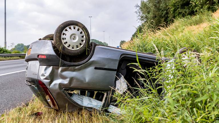 De auto kwam ondersteboven in de berm terecht. (Foto: Marcel van Dorst)