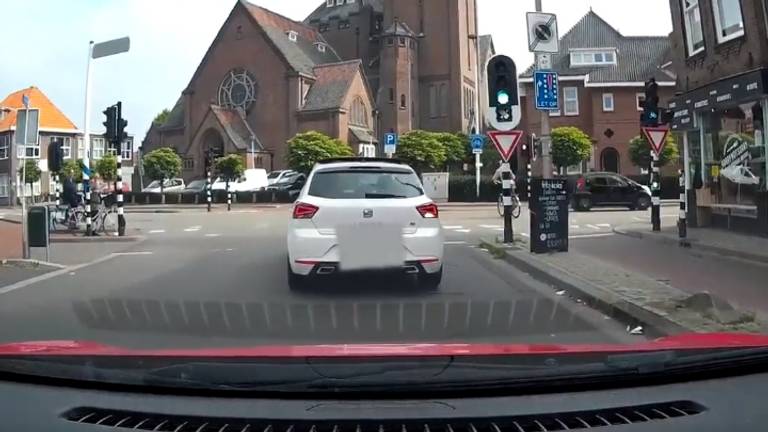 De kleine zwarte auto scheurt door rood.