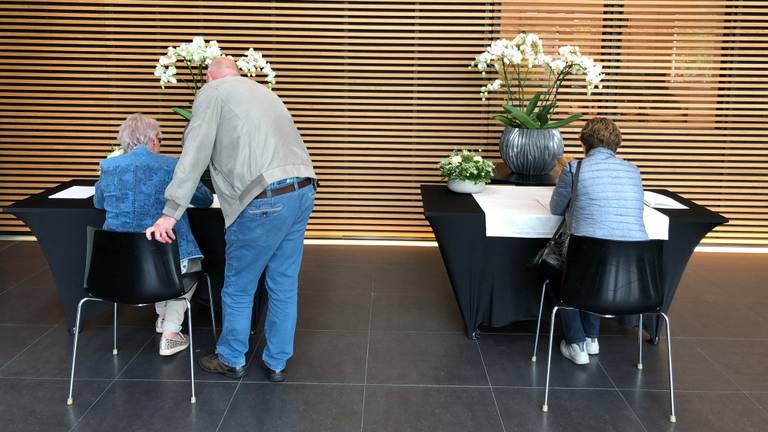 Verschillende mensen tekenen het rouwregister. (Foto: Imke van de Laar)