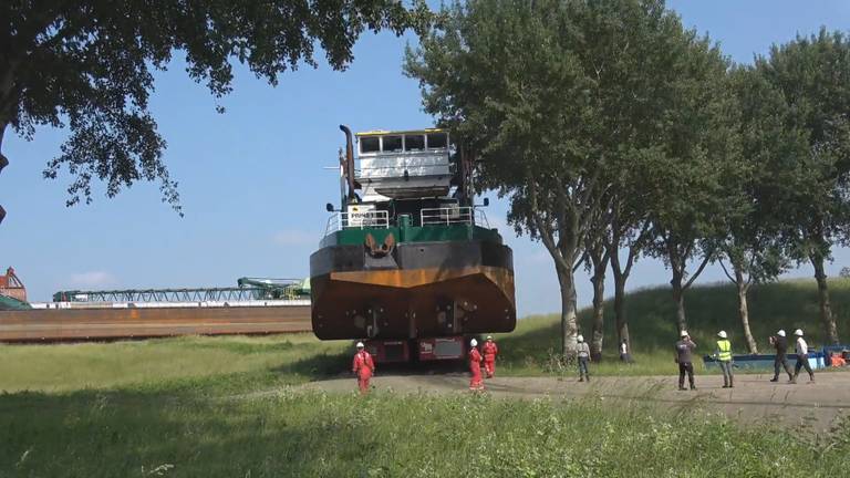 Baggerboot over land onderweg naar het water in het spaarbekken (foto Evides / Mediataal)