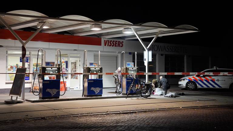 Omstanders bekommeren zich om de gewonde medewerker van het tankstation in Beek en Donk. Foto: Danny van Schijndel