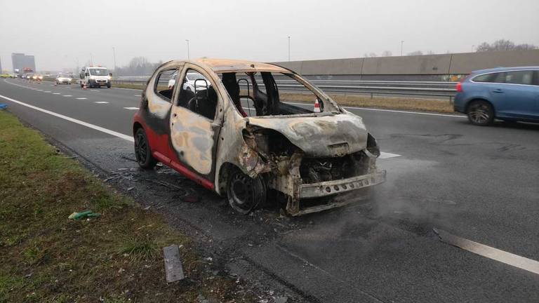 De rode auto is volledig uitgebrand.