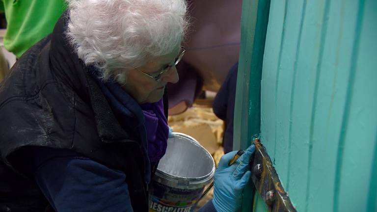 Miep Verburg druk bezig met het schilderen van details