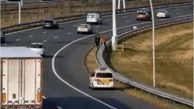 De lifters worden opgepikt door een politieauto (beeld: Rijkswaterstaat).