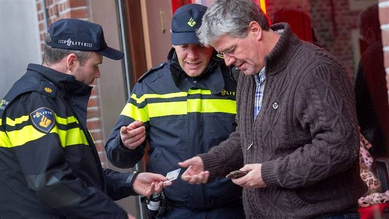 Agenten controleren iemand op straat. (Archieffoto: politie.nl)