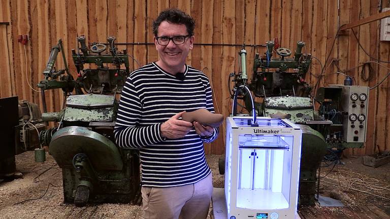 John van de Laar laat de eerste klomp uit de 3D-printer zien