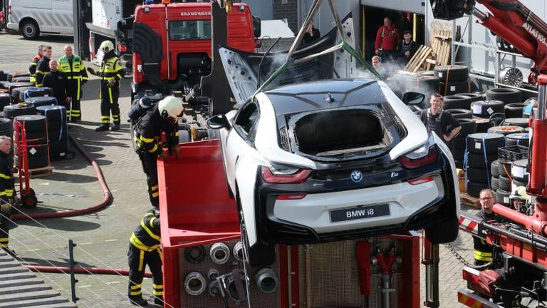 De auto werd in een waterbak van de brandweer ondergedompeld. (Foto: Perry Roovers/SQ Vision)