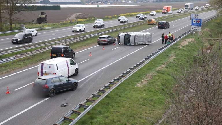 Op de A50 richting Eindhoven lag een busje op zijn kant. (Foto: Gabor Heeres/SQ Vision)