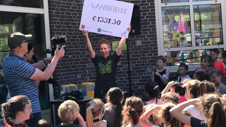 Henny neemt cheque met opbrengst sponsorloop in ontvangst.