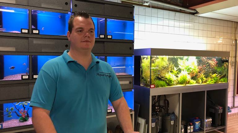 Eduard tussen de aquariums in zijn winkel