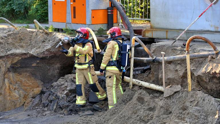 Een brandweer man krijgt ducttape toegeworpen om de gasleiding provisorisch te herstellen. (Foto: Berry van Gaal SQ Mediaproduckties)
