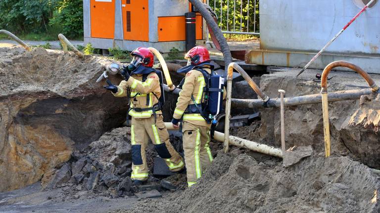 Een brandweer man krijgt ducttape toegeworpen om de gasleiding provisorisch te herstellen. (Foto: Berry van Gaal SQ Mediaproduckties)