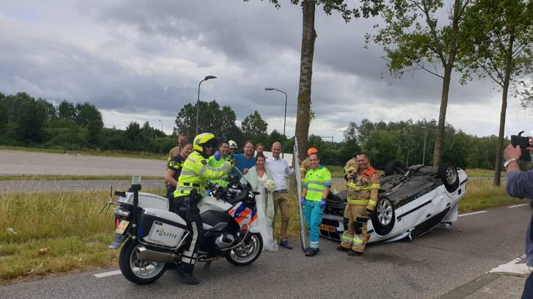 Het bruidspaar na het ongeluk met alle hulpverleners (Foto: Ruud van Rosmalen).