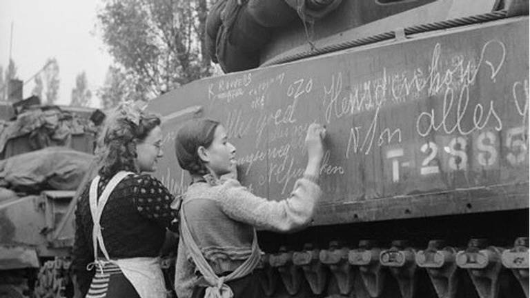 De bekende foto van twee Bredase meisjes en een Poolse tank. De meisjes deden maar alsof ze schreven... op verzoek van de fotograaf.