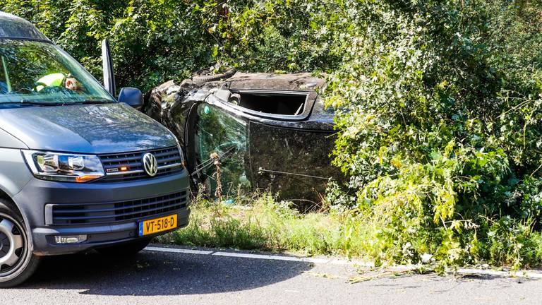 De auto van de vrouw ligt op z'n zijkant tegen een boom (foto: Dave Hendriks / SQ Vision).