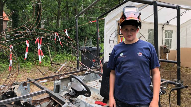 Daan met zijn lasmasker bij de wagen. (Foto: René van Hoof)