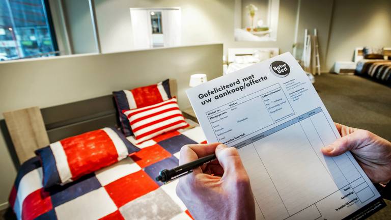 Een verkoper houdt een offerte vast voor een aankoop bij beddenwinkel Beter Bed. (Foto: ANP)