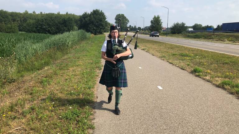 Doedelzakspeelster Sylvia Debie oefent langs een provinciale weg bij Sint-Oedenrode.