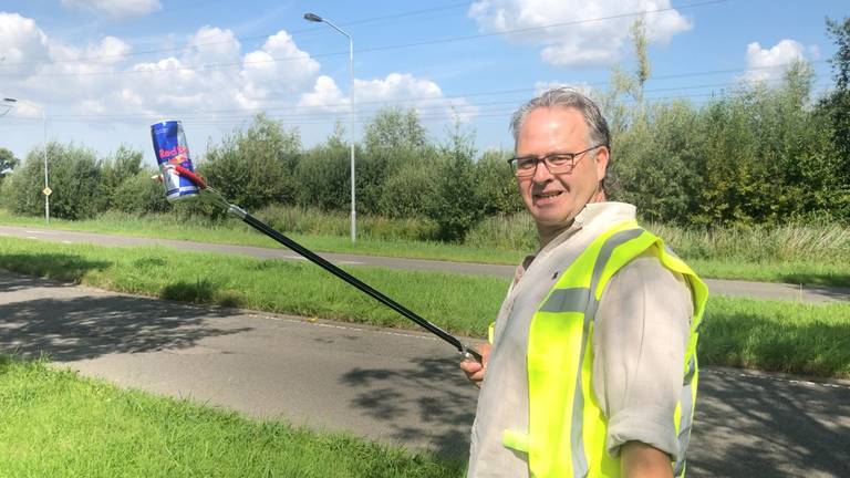 Marco Jansen haalt zwerfafval uit de berm in de Haagse Beemden. (P)