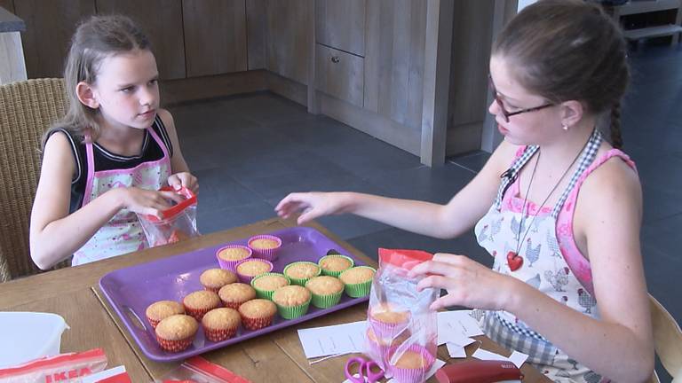 Manouk en Eva pakken de eerste bestelling cupcakes in.