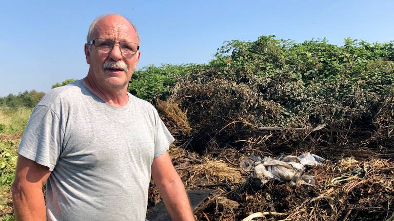 Piet de Groot bij de afvalberg die zondag in de hens ging (foto: Erik Peeters).