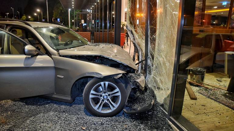 De auto eindigde tegen de gevel van het Bastion Hotel in Tilburg. (Foto: Toby de Kort)