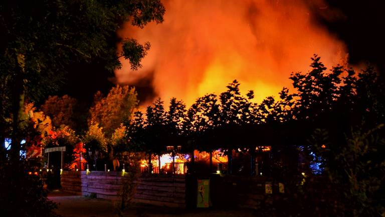 Hoge vlammen slaan uit de chalets. (Foto: Anthony DeCock/De Kort Media)