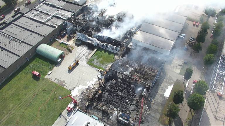 De door brand verwoeste bedrijven op industrieterrein Kraaiven in Tilburg. (Dronebeeld BrandweerMWB)