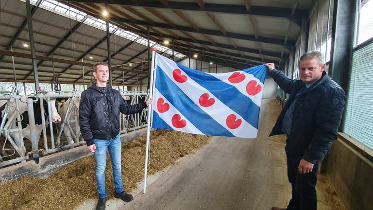 Jan van de Ven en zijn zoon hijsen het bekende blauwwitte vaandel met de rode lelies