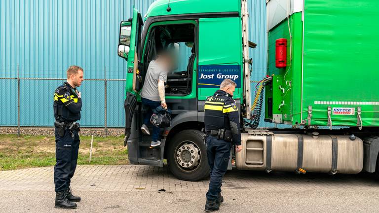 De gewonde trucker pakt zijn spullen uit de cabine. (Foto: Marcel van Dorst/SQ Vision)