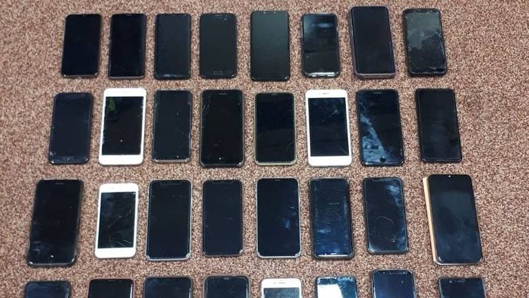 De man had 32 telefoons bij zich (foto: Facebook politie gemeente Gilze en Rijen).