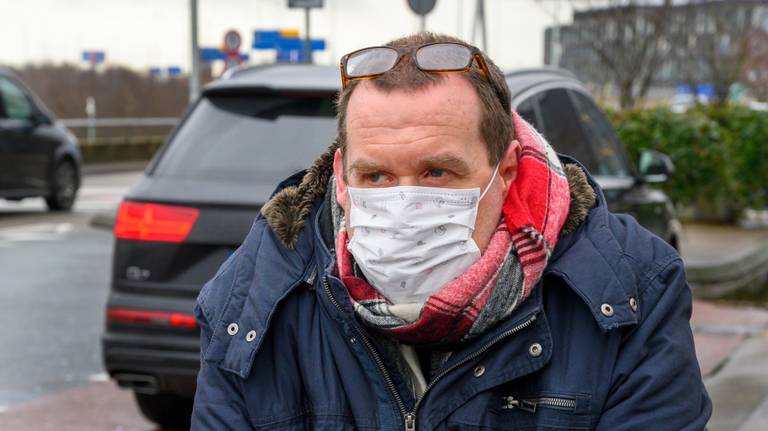Een reiziger uit Peking draagt een mondkapje in verband met het coronavirus (foto: ANP 2020/Evert Elzinga)