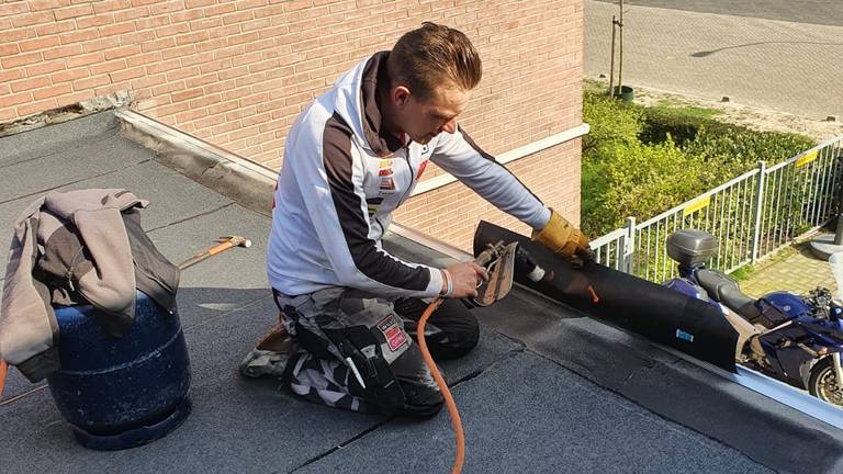 Etienne Bax niet aan het crossen, maar aan het werk op het dak.