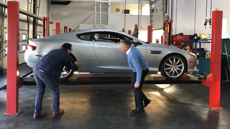 Renald en Anton van Dijke nemen de schade aan de James Bond wagen op.