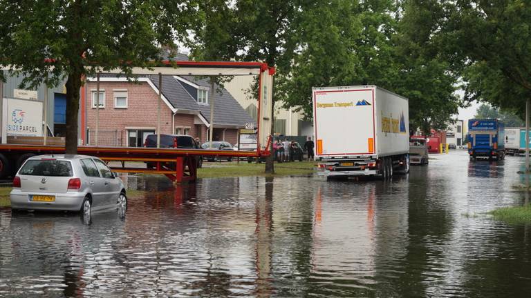 Ook vrachtwagens moeten zich een weg door het water banen (Foto: Erik Haverhals).