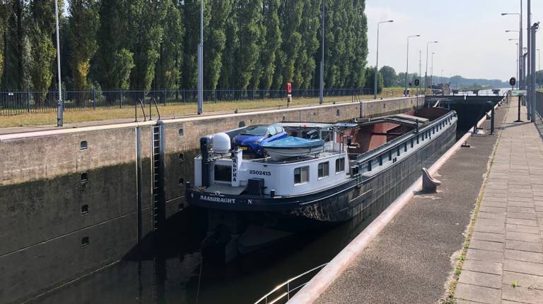 Een boot vaart door de sluis bij Schijndel.