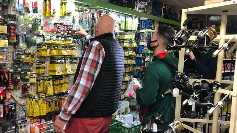 Ad van Zon helpt een klant in zijn winkel (Foto: René van Hoof)