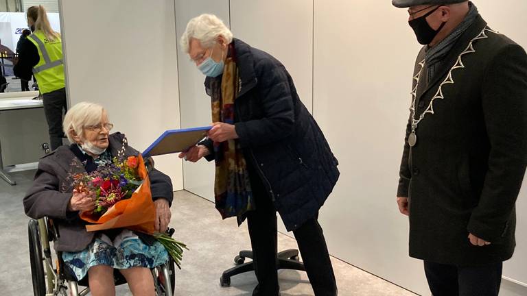 Zuster Marcelliana ontvangt na haar vaccinatie bloemen van de burgemeester (foto: gemeente Meierijstad).