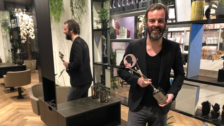 Kapper Arjan Bevers met trofee in zijn lege kapsalon (Foto: Alice van der Plas)