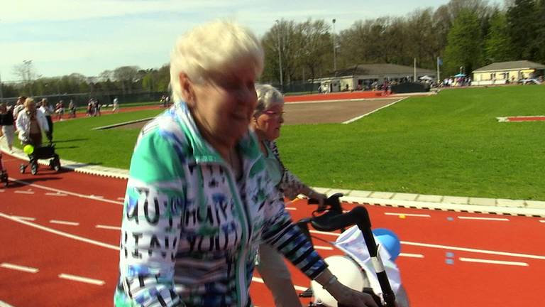 Racende bejaarden scheuren met piepende banden over atletiekbaan