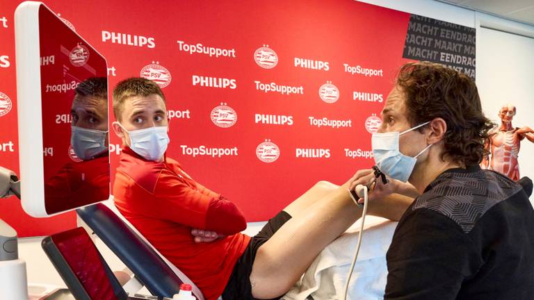 PSV-clubarts Wart van Zoest demonstreert de 3D echo bij PSV'er Ryan Thomas 