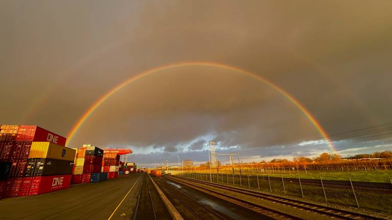 Een dubbele regenboog over het spoor