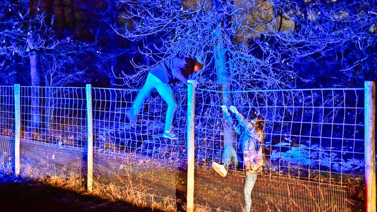 Agenten klimmen over het hek om de vrachtwagendieven te zoeken (foto: SQ Vision).