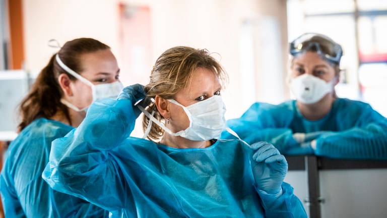 Zorgpersoneel aan het werk in beschermende kleding. Foto: ANP