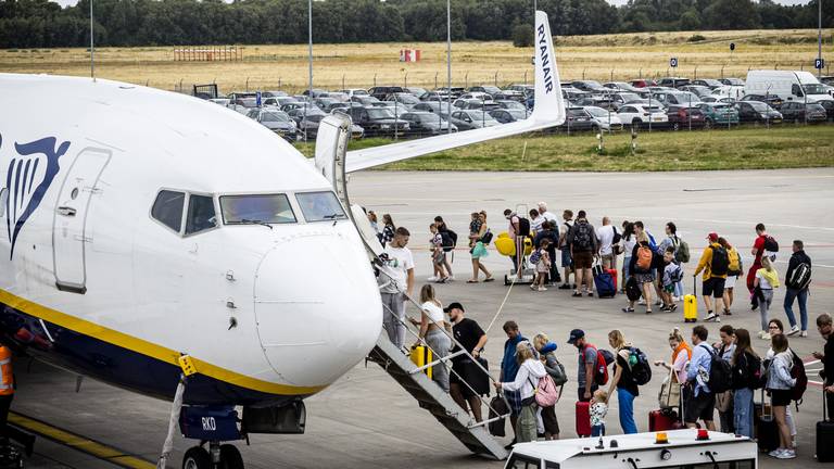 Passagiers in de rij om in te stappen (foto: ANP).